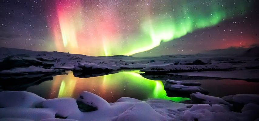 A beautiful green and red aurora dancing over the Jokulsarlon lagoon, Iceland