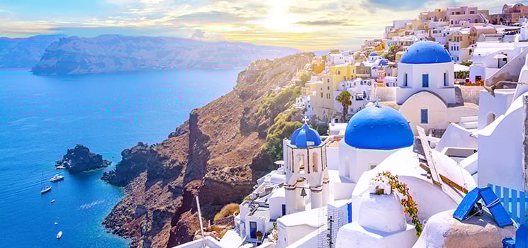 Beautiful Oia town on Santorini island, Greece. Traditional white architecture and greek orthodox churches with blue domes over the Caldera, Aegean sea.