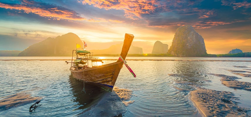 Beautiful sunset at tropical sea with long tail boat in south Thailand