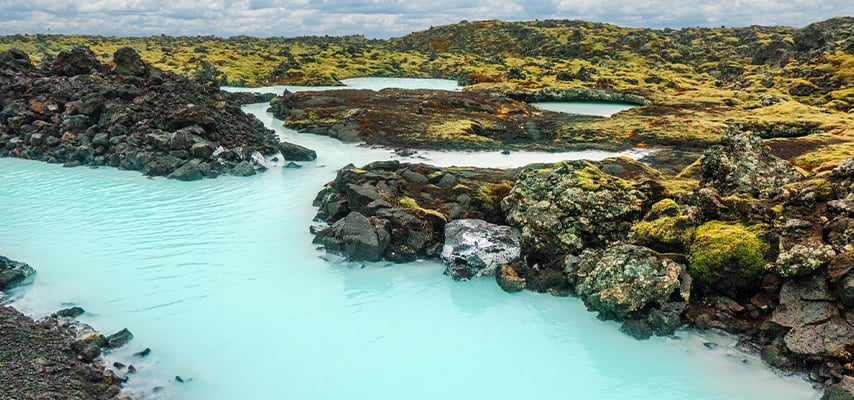 The amazing volcanic landscape near the Blue Lagoon in south west Iceland. Gorgeous blue water makes its way between moss covered basalt