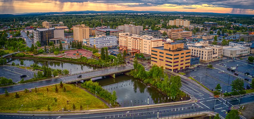 Aerial view of downtown Fairbanks with river, bridge, and buildings at sunset