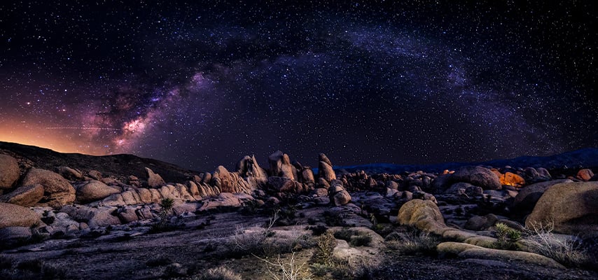 Milky Way over Joshua Tree boulder formations at night