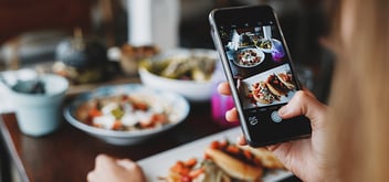 woman taking photo of a large spread of food 