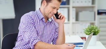 Advisor on phone and working on laptop