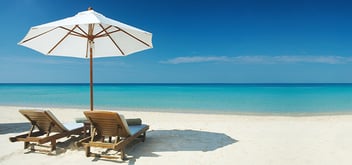 beach chairs under umbrella at a tropical beach
