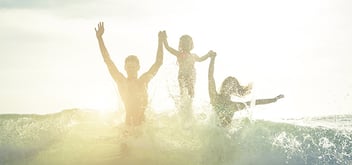 family jumping in the ocean