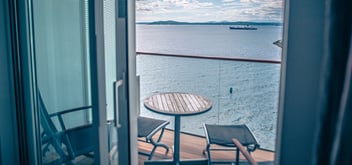bright cruise ship luxury room with balcony view