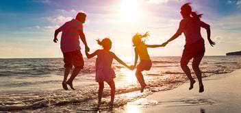 happy family jumping together on the beach