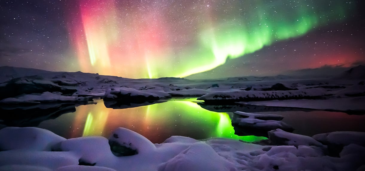 A beautiful green and red aurora dancing over the Jokulsarlon lagoon, Iceland