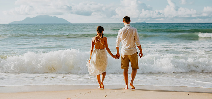 honeymoon wedding couple on beach at sunset