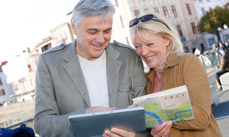 A man and a woman look at a map while on vacation